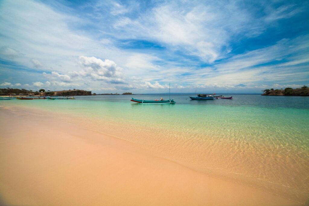 Close up pasir pink Pantai Tangsi Lombok dengan tekstur halus bercampur serpihan karang merah